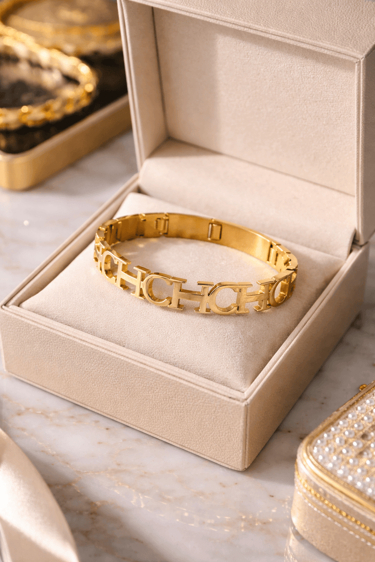 Gold bracelet in an open jewelry box on a marble surface