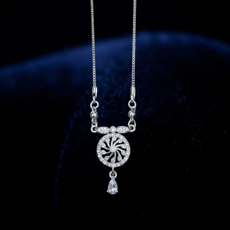 Silver necklace with a decorative pendant on a dark background