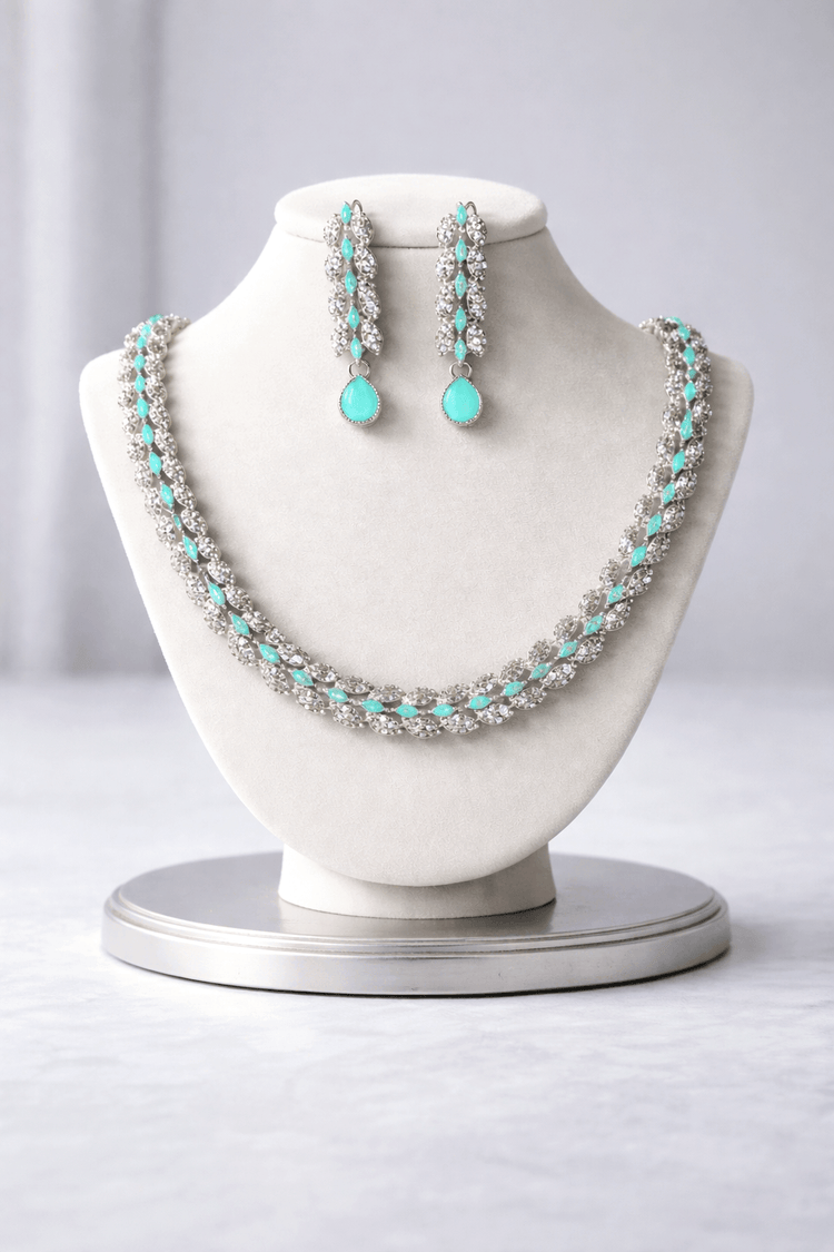 Jewelry set with necklace and earrings on a mannequin bust against a gray background