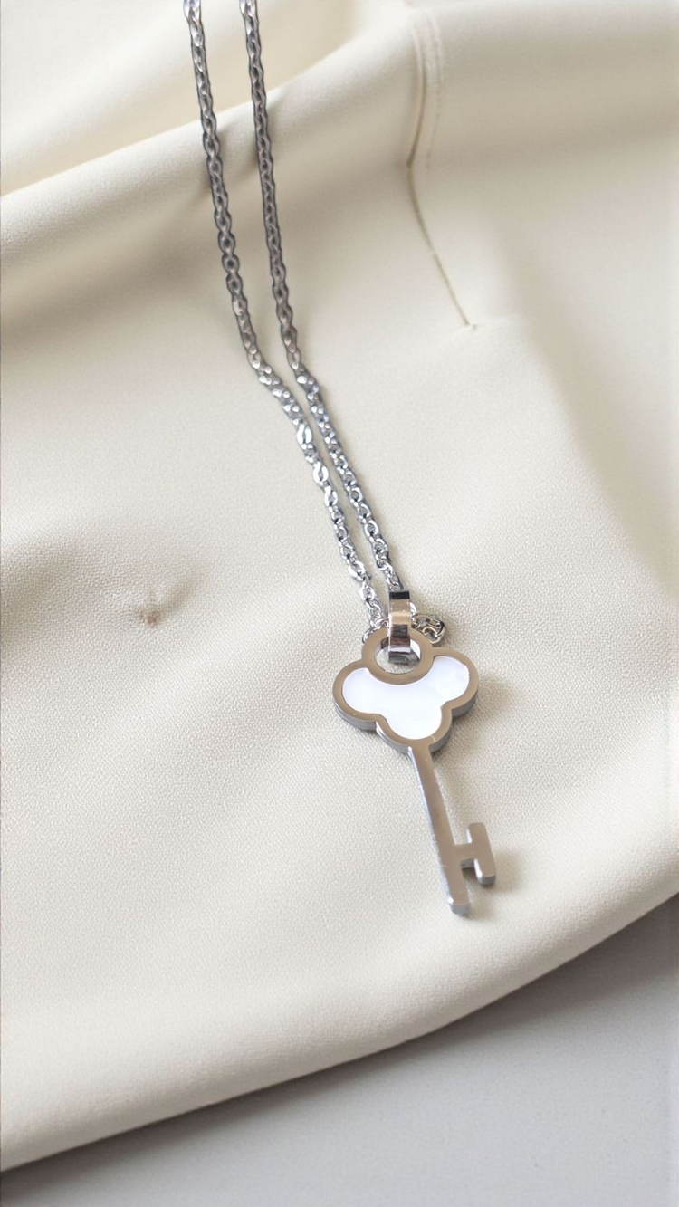 Silver key-shaped pendant necklace on a white background