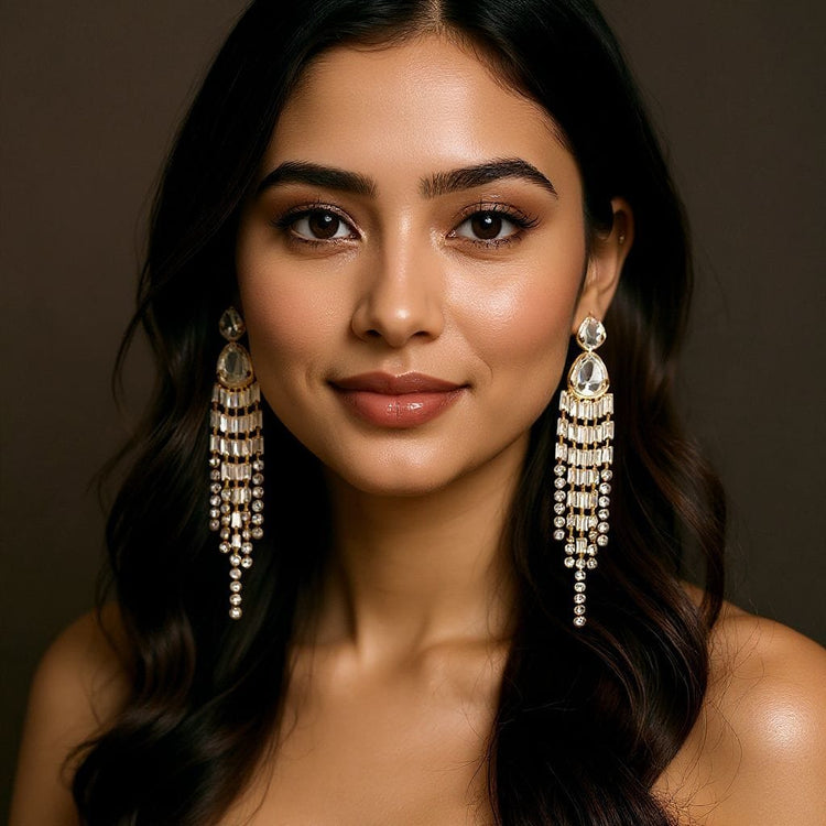 Woman wearing long, dangling earrings with a neutral background