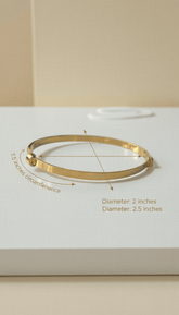 Gold bracelet on a white surface with measurements indicated