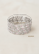 Silver bracelet with pink stones on a beige background, showing measurements and product code.