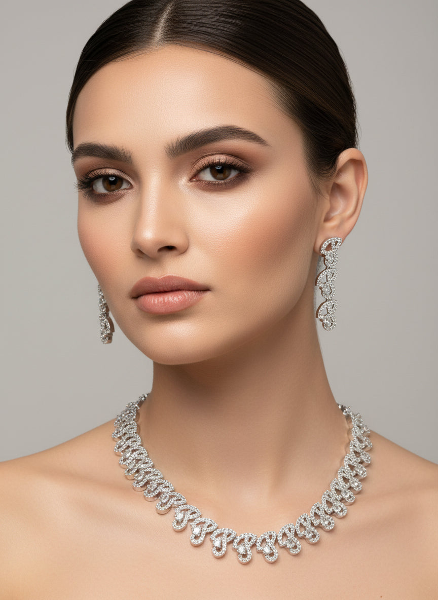 Woman wearing a silver necklace and earrings against a gray background