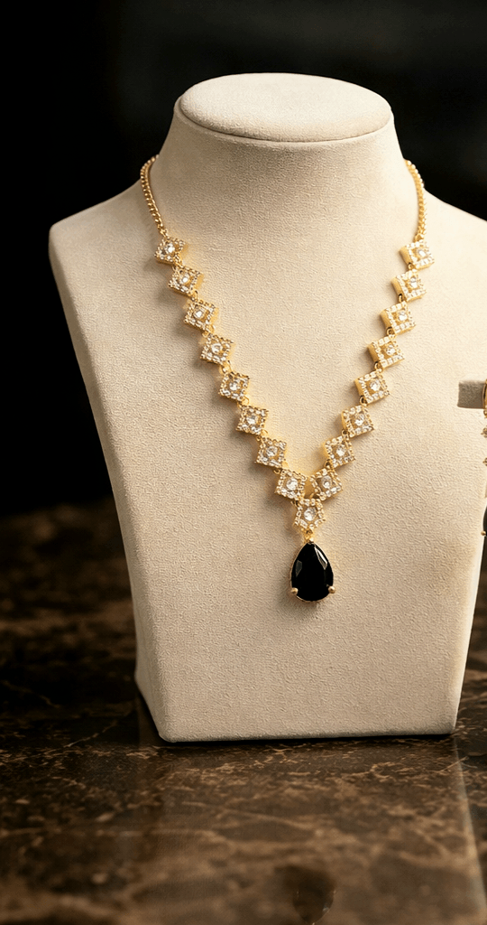 Necklace with a black teardrop pendant on a mannequin bust against a dark background