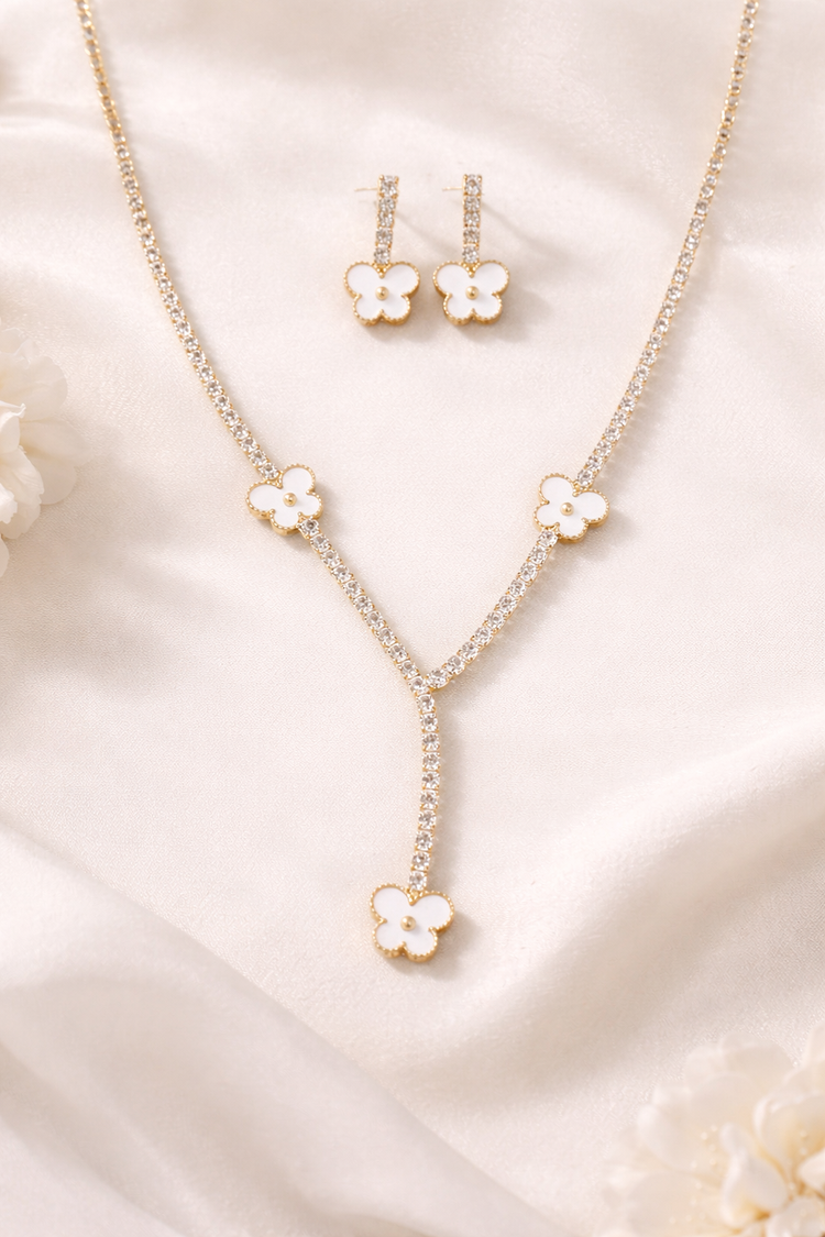 Jewelry set with floral pendant necklace and earrings on a soft fabric background