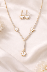 Jewelry set with floral pendant necklace and earrings on a soft fabric background