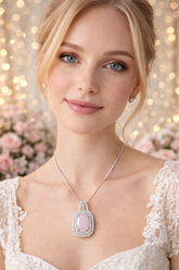 Woman wearing a necklace with a pink pendant against a blurred floral and light background