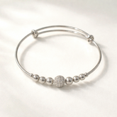 Silver bracelet with spherical beads on a white background