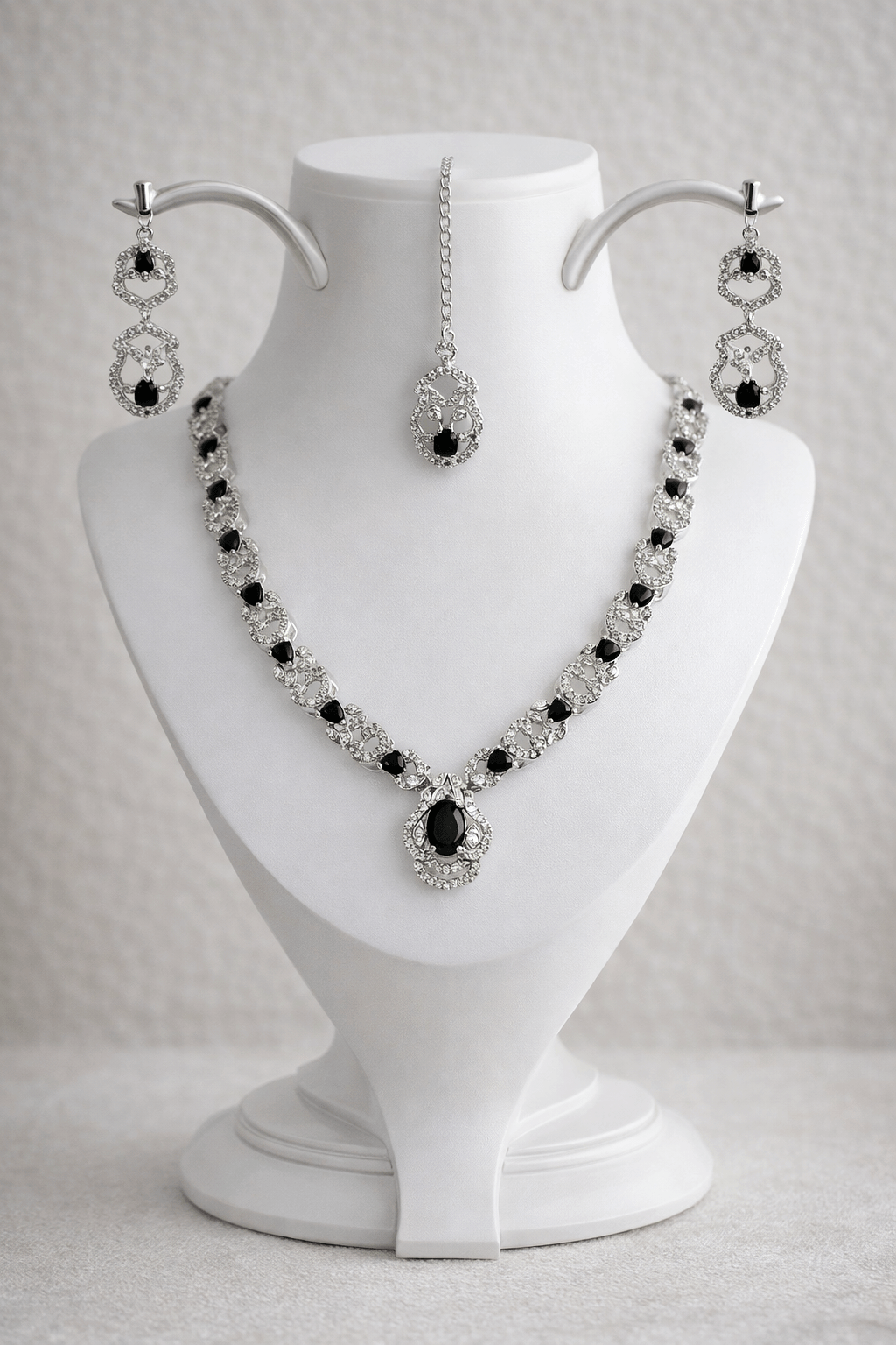 Jewelry set with necklace and earrings on a white mannequin bust.