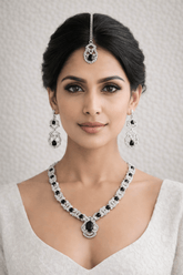 Woman wearing a black and white jewelry set with a neutral background