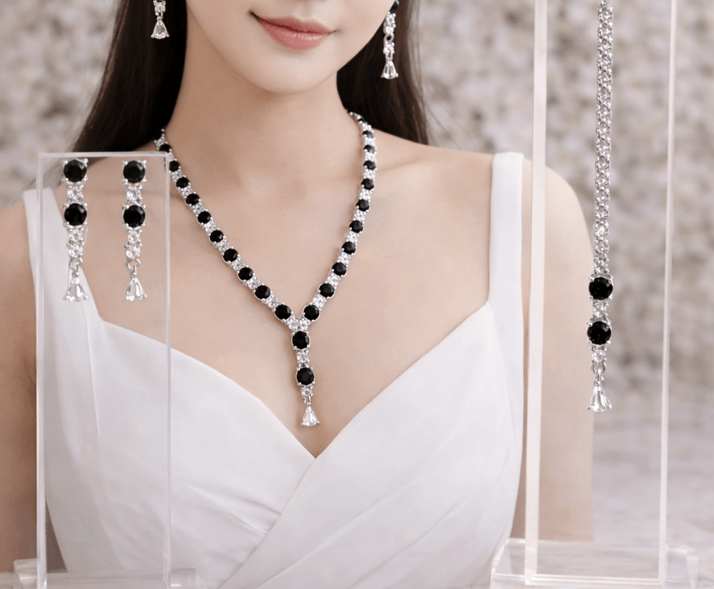 Woman wearing a black and white beaded necklace with matching earrings against a neutral background