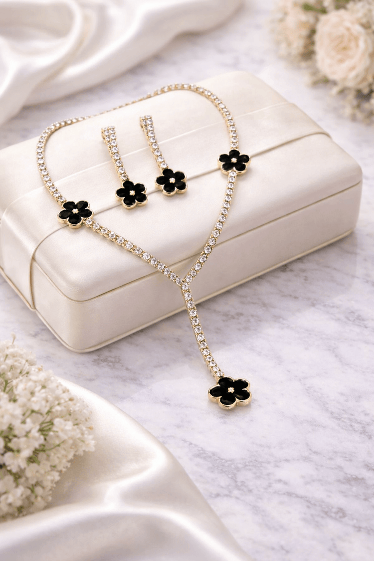Jewelry set with necklace and earrings on a white box with flowers around