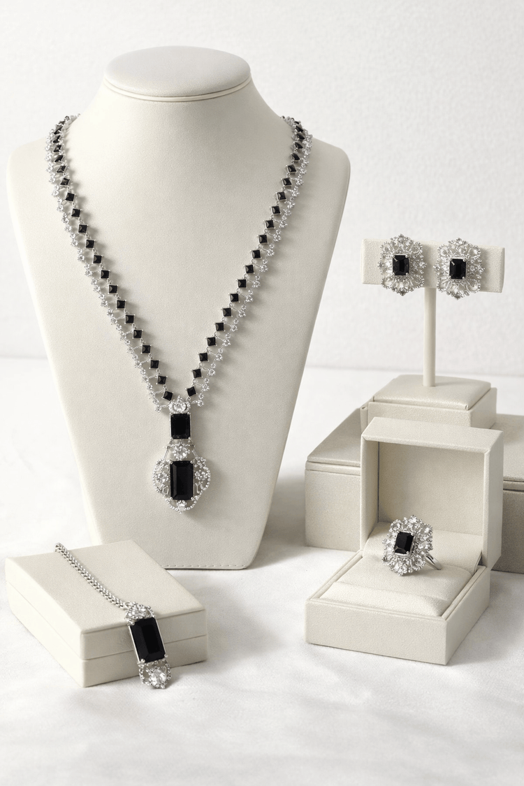 Black and white jewelry set on a mannequin and display stands against a white background