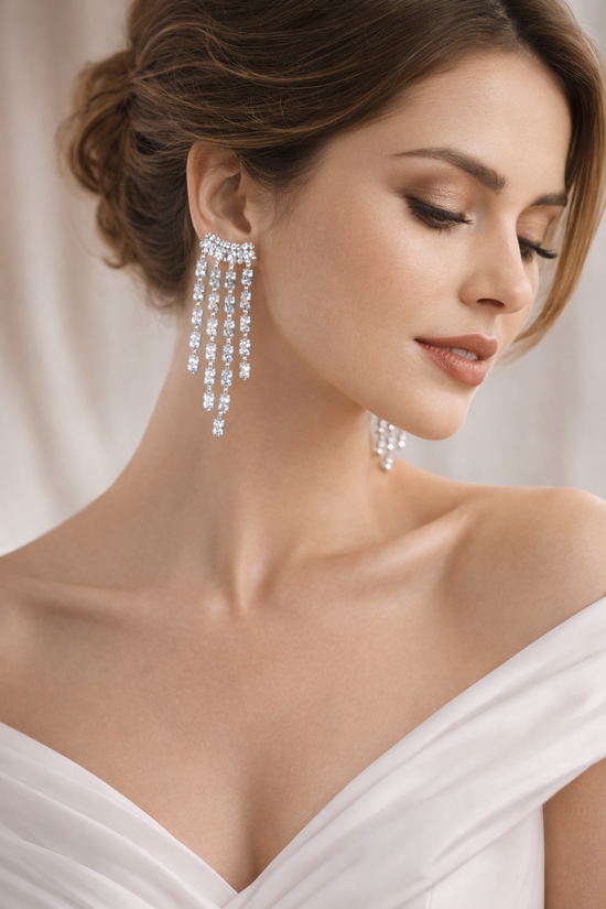 Woman wearing sparkling silver earrings against a neutral background