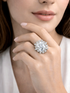 Close-up of a hand wearing a diamond ring with a blurred background