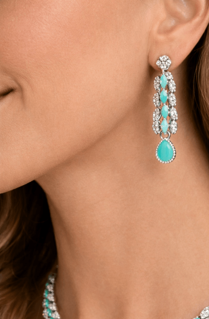 Close-up of a person wearing turquoise and silver earrings.