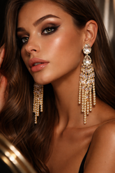Close-up of a woman wearing sparkling gold earrings with a blurred background