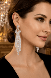 Close-up of a woman wearing sparkling silver earrings with a blurred background