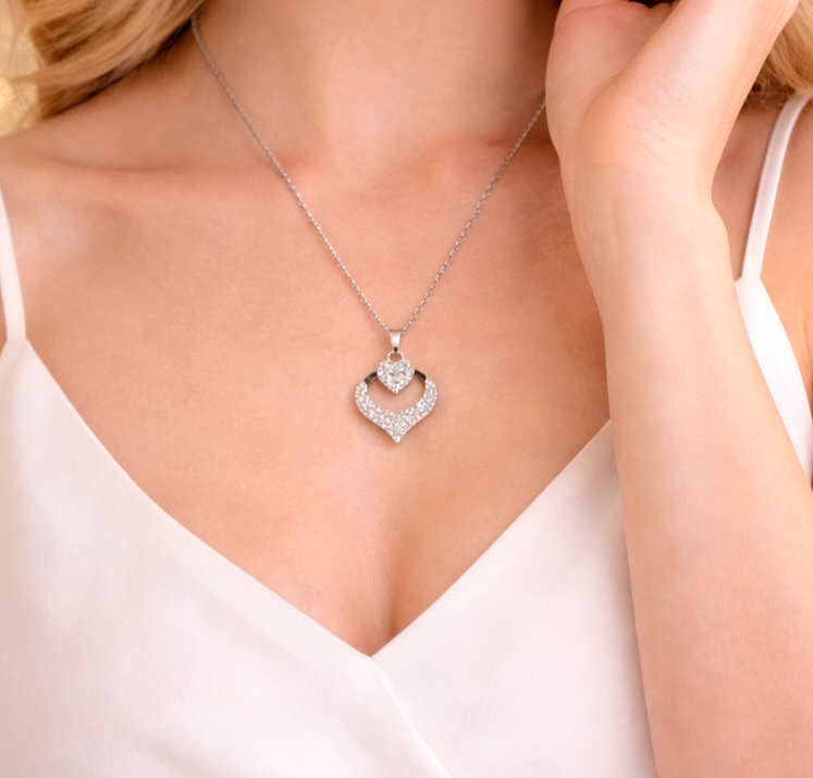 Silver heart-shaped necklace worn by a model