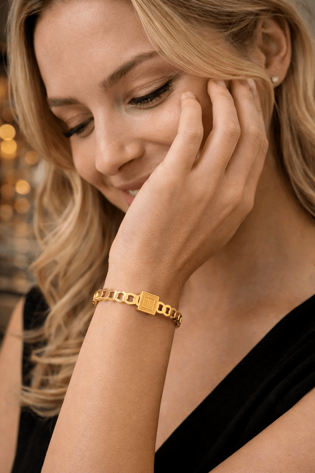 Woman wearing a gold bracelet with a blurred background