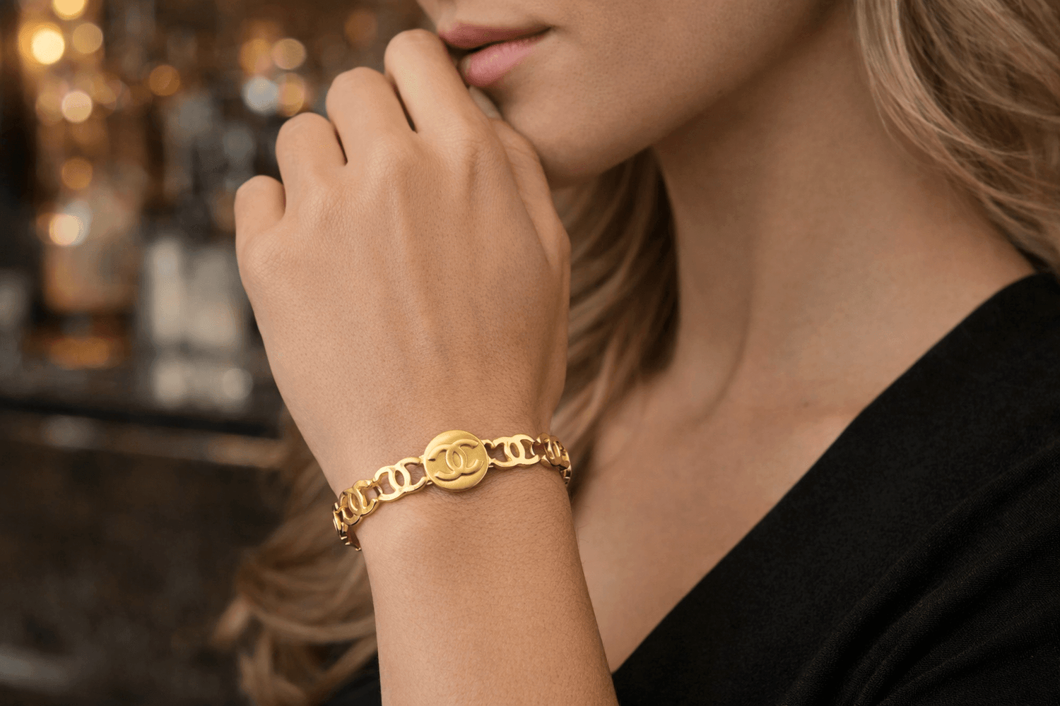 Close-up of a person wearing a gold bracelet with a blurred background