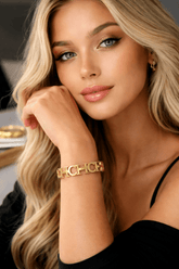 Woman wearing a gold bracelet with a blurred background
