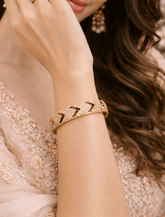 Gold bracelet on a wrist with a blurred background