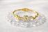 Gold bracelet with butterfly design on a white background
