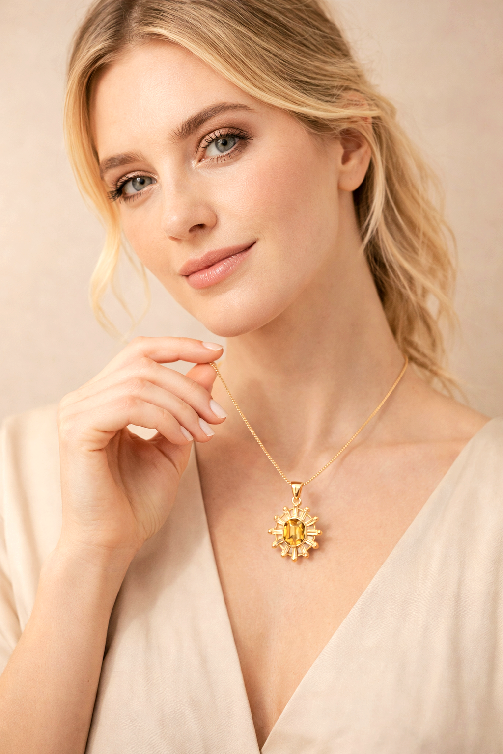 Woman wearing a gold necklace with a sunflower pendant against a beige background