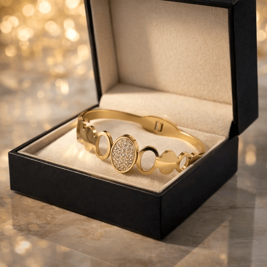 Gold bracelet in a black jewelry box with a blurred golden background
