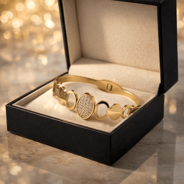 Gold bracelet in a black jewelry box with a blurred golden background