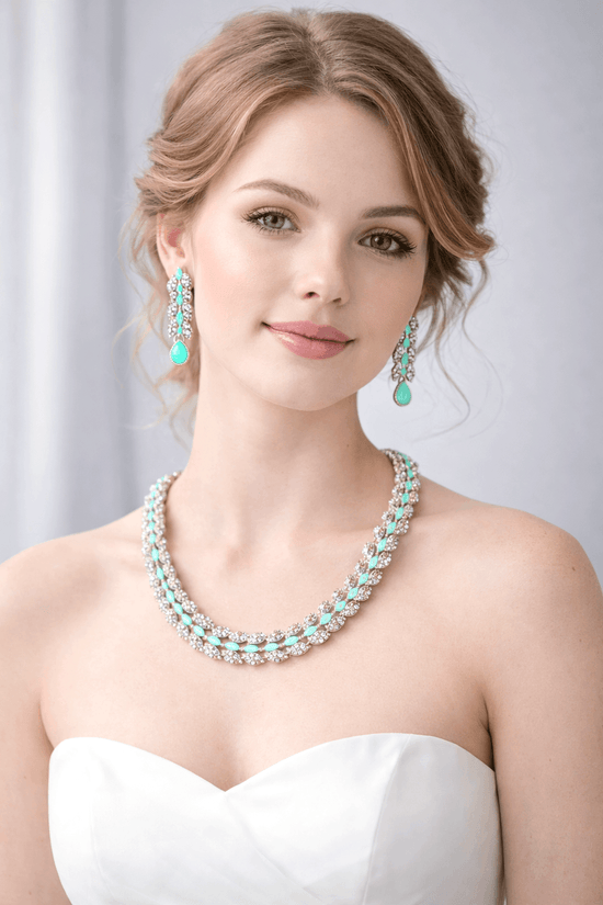 Woman wearing a turquoise necklace and earrings against a plain background