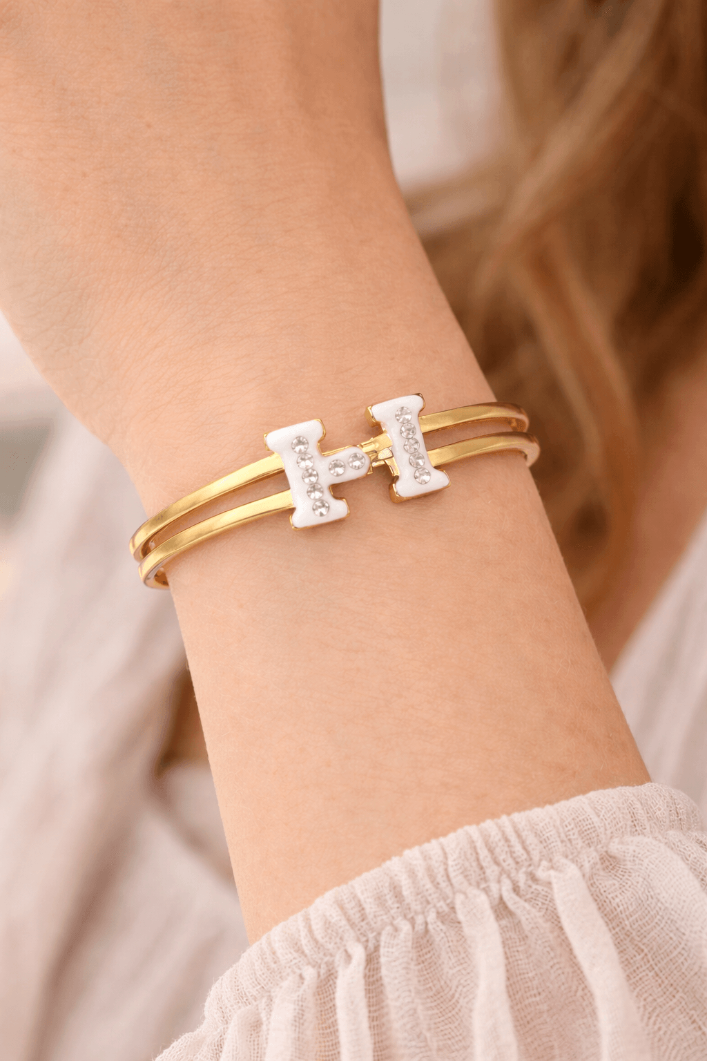 Gold and silver bracelet on a wrist with a blurred background