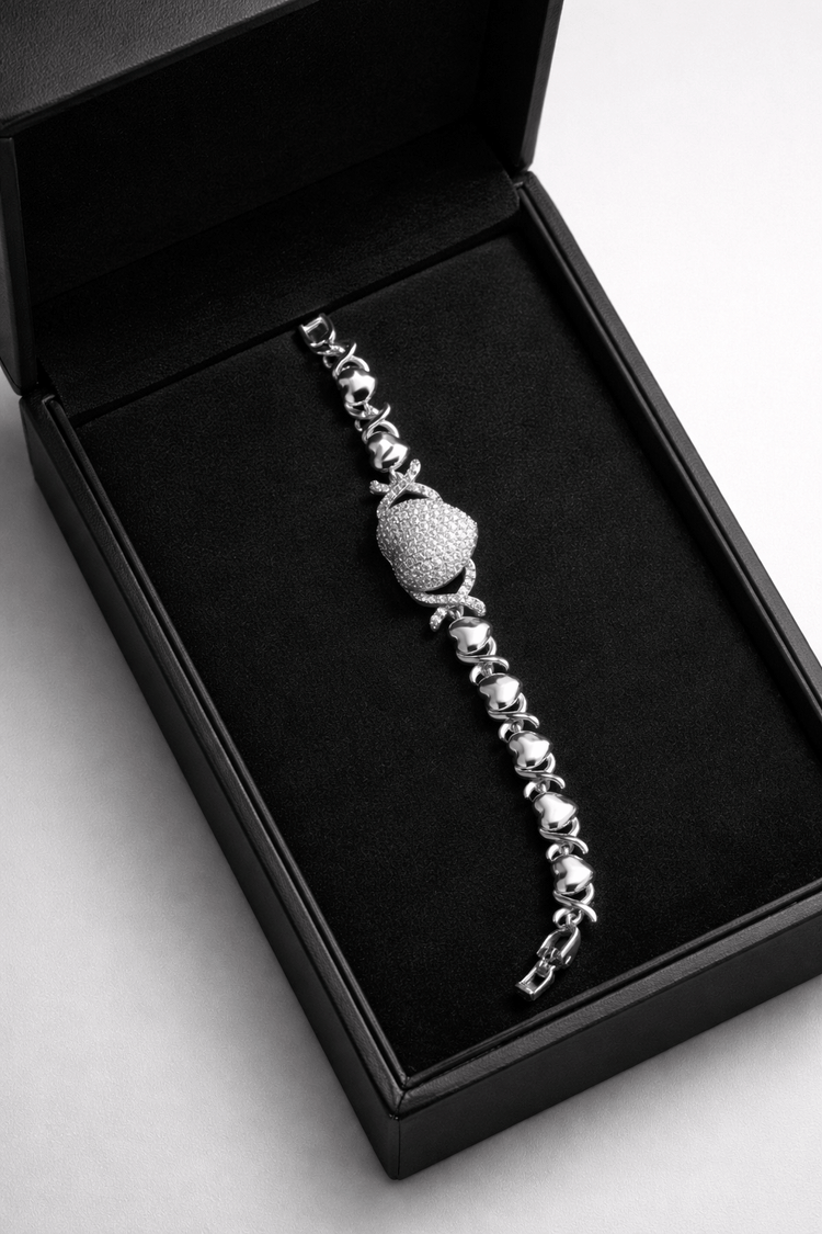 Silver bracelet with a beaded design in a black box on a light gray background
