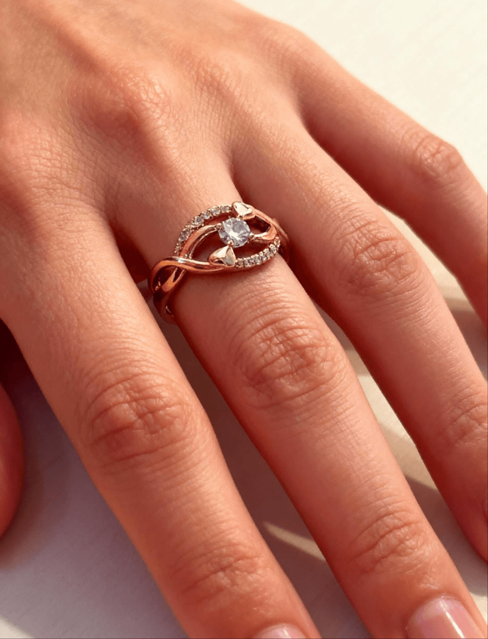 Rose gold ring with a diamond on a person&