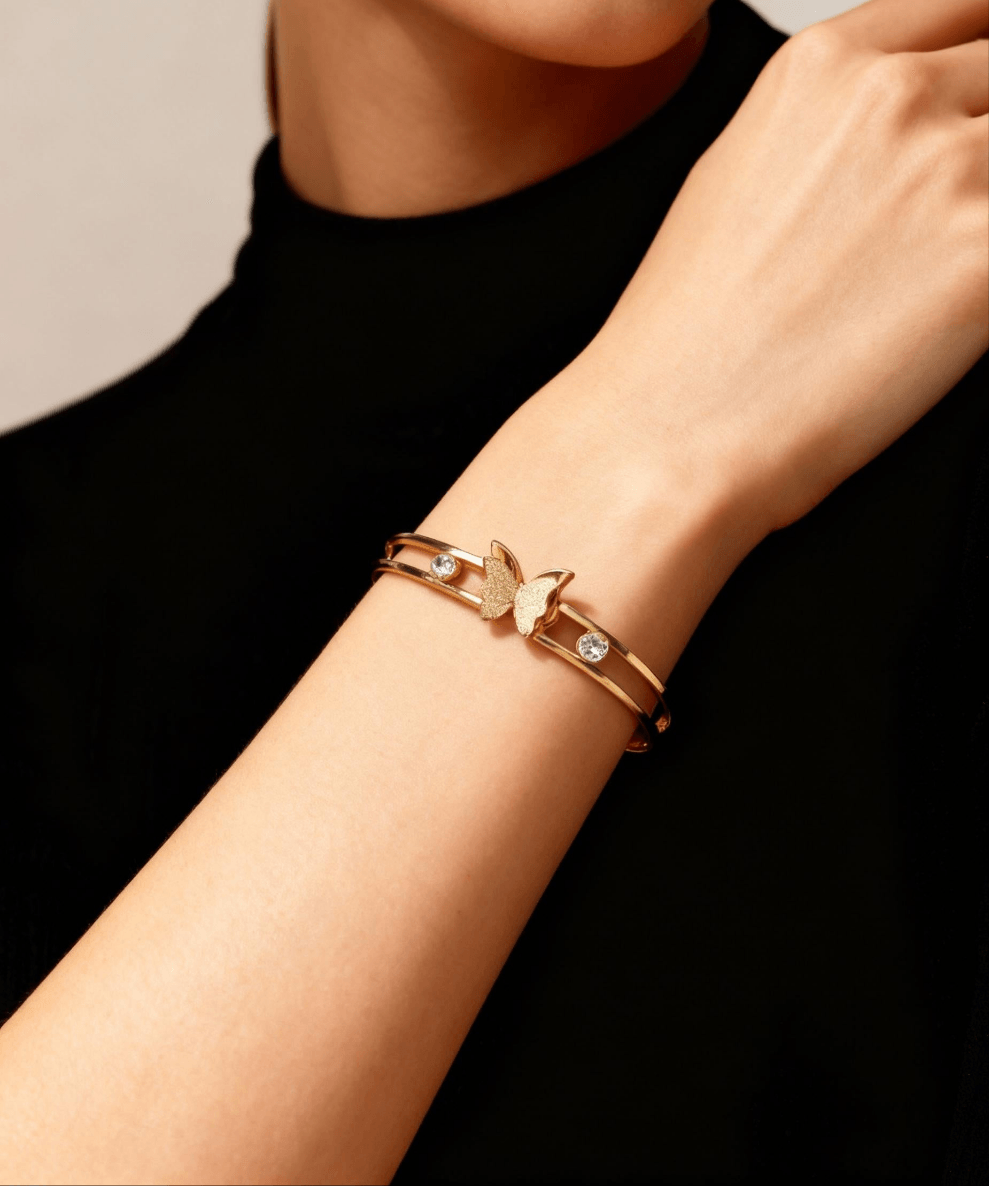 Gold bracelet with a butterfly clasp on a person&