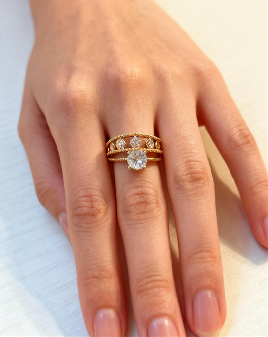 Close-up of a hand wearing two gold rings with diamond accents on a light background