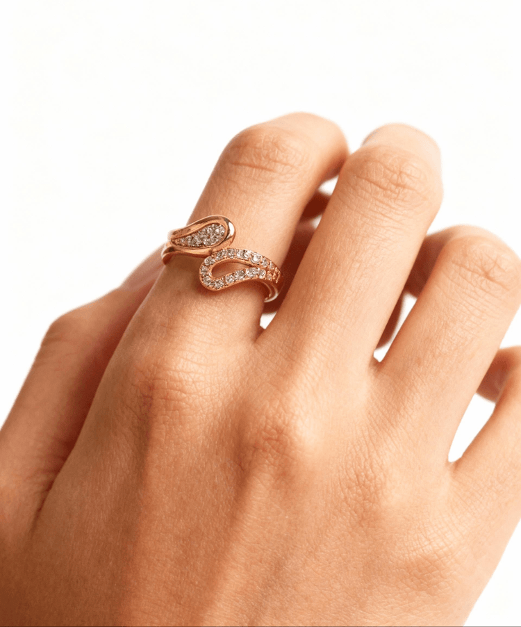 Gold ring with diamond accents on a hand against a white background