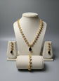 Jewelry set including necklace, earrings, and bracelet on a gray background