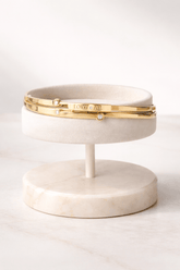 Marble jewelry stand with gold band on a white background