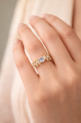 Gold ring with a diamond on a hand against a soft background