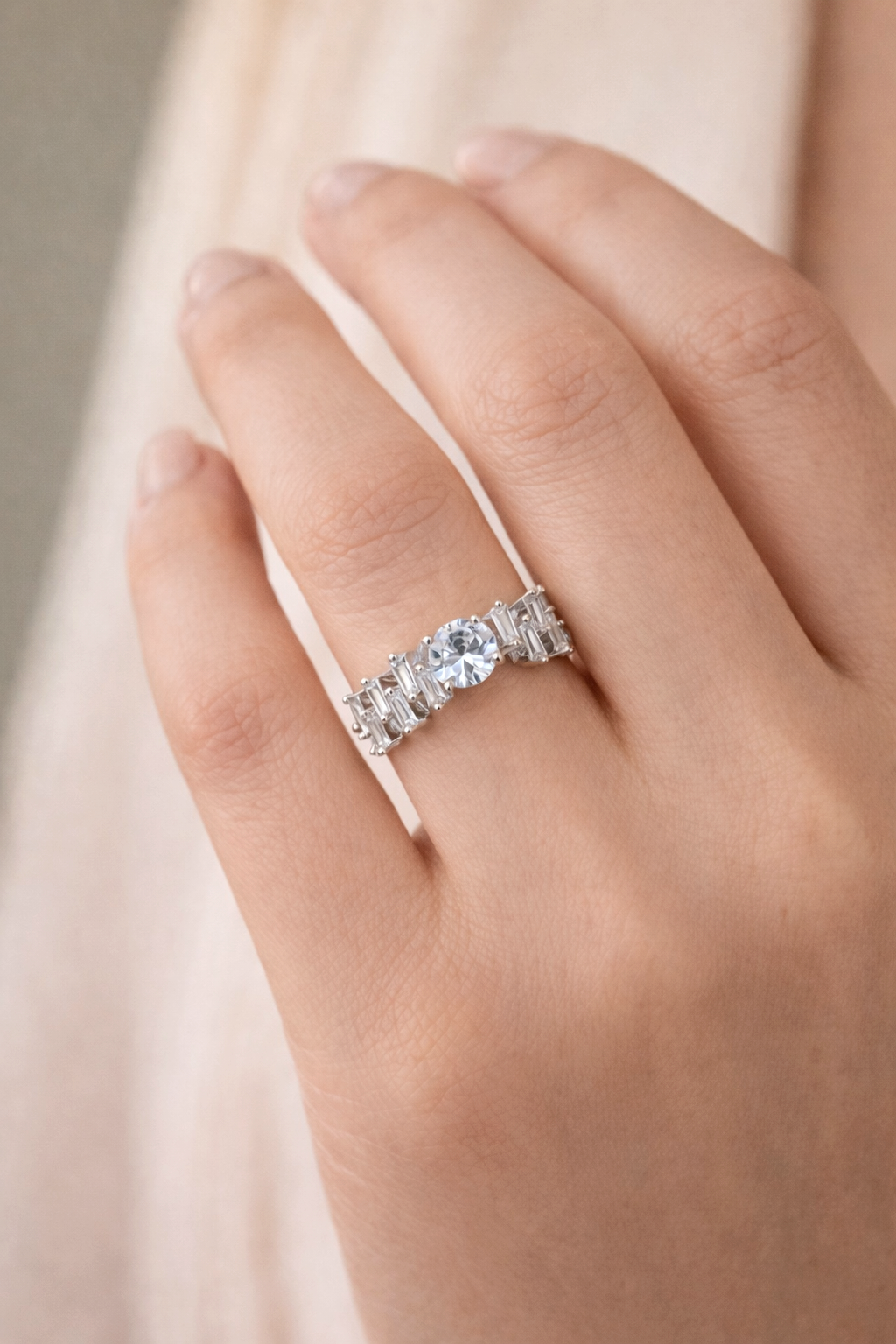 Silver ring with a large central gemstone on a hand against a soft background