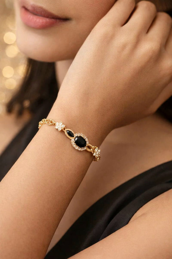Gold bracelet with black gemstones on a person&