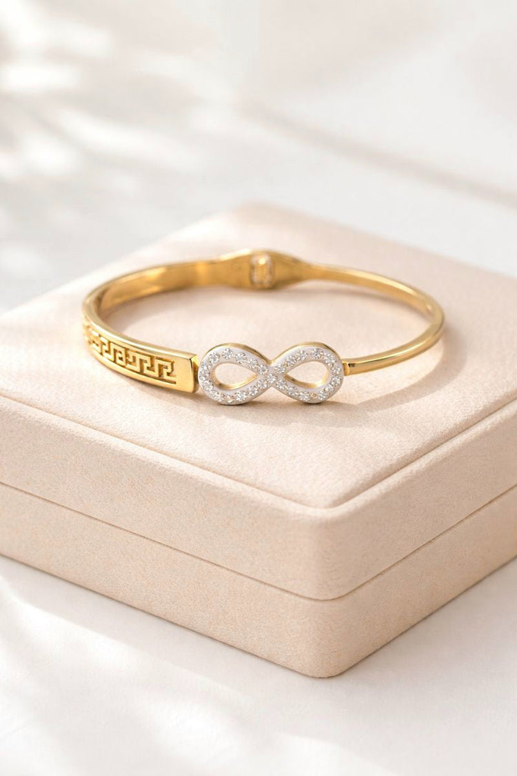 Gold bracelet with infinity symbol on a beige jewelry box