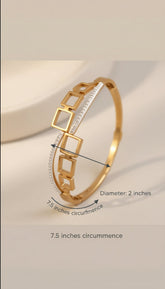 Gold bracelet with measurement details on a beige background
