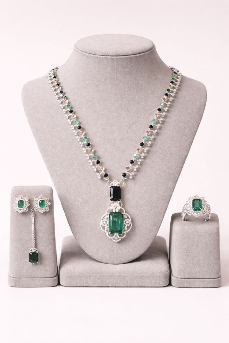 Jewelry set with necklace, earrings, and ring on a gray stand against a white background