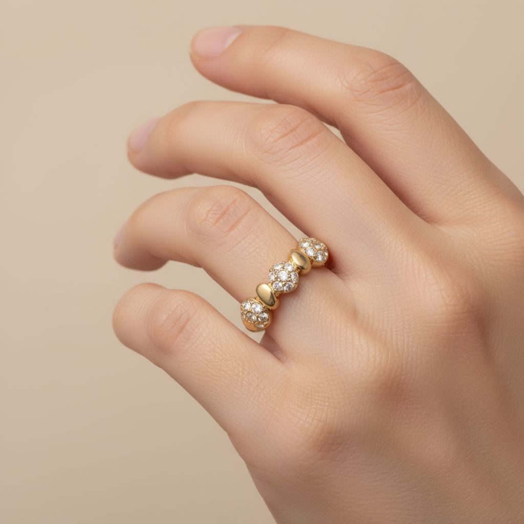 Gold earring with embedded crystals on a light beige background