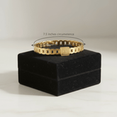 Gold ring on a black velvet stand with measurement text