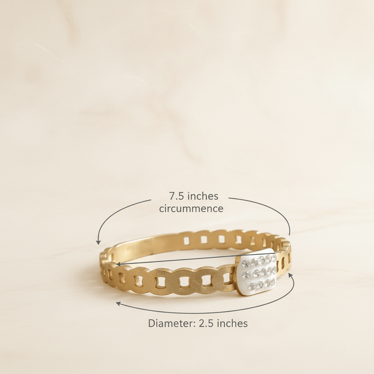 Gold bracelet with measurement details on a beige background